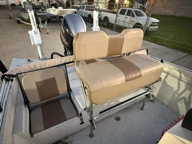 Slide: The Image of 2020 Xpress H20B boat with tan seating and motor, parked in a lot. - 7