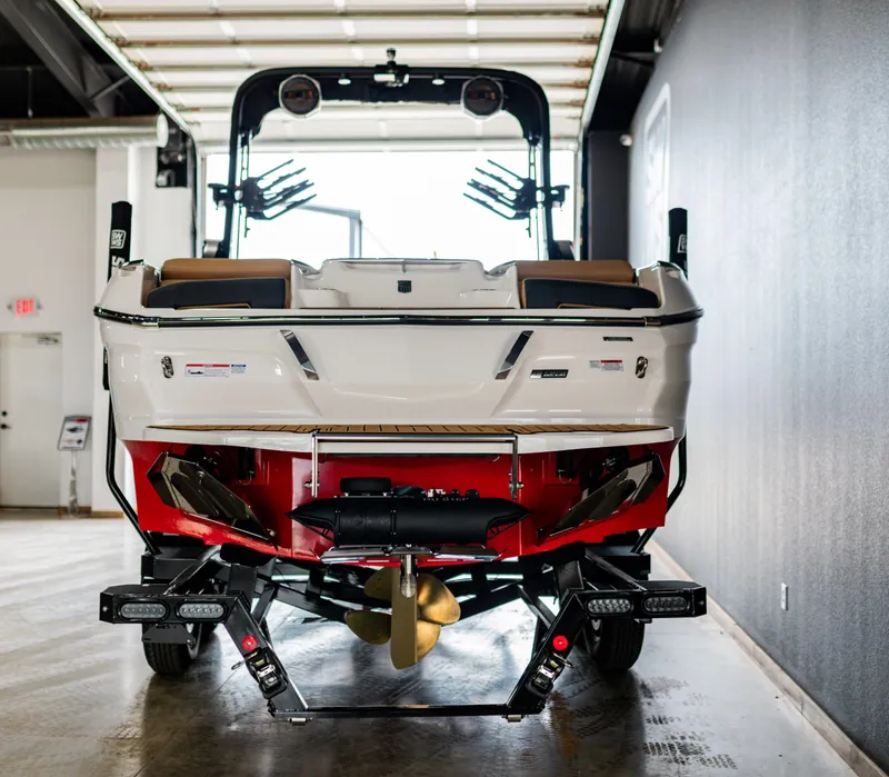 Slide: The Image of 2025 MasterCraft X24 boat in a garage, rear view showcasing design and features. - 11