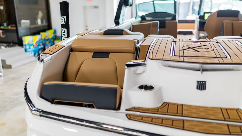 Slide: The Image of 2025 MasterCraft X24 boat interior with tan seating and wood accents. - 9