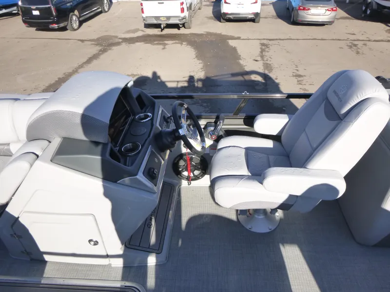 Slide: The Image of 2025 Regency 230 LE3 boat interior with steering wheel and captain's chair. - 14
