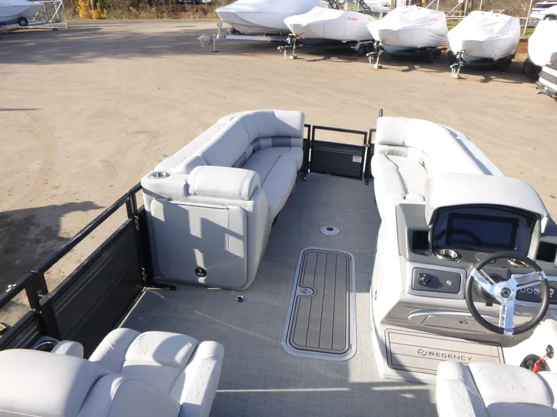 Slide: The Image of 2025 Regency 230 LE3 pontoon boat interior with plush seating and modern dashboard. - 22