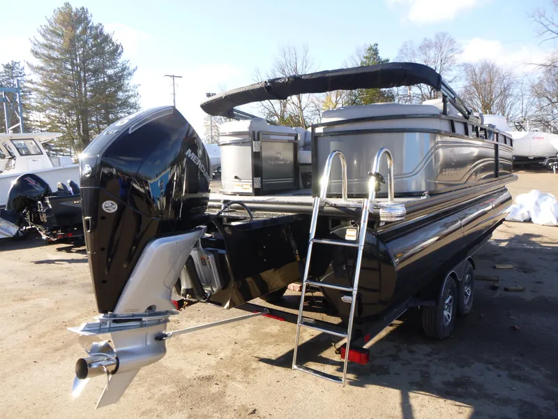 Slide: The Image of 2025 Regency 230 LE3 pontoon boat with outboard motor and ladder, parked outdoors. - 6