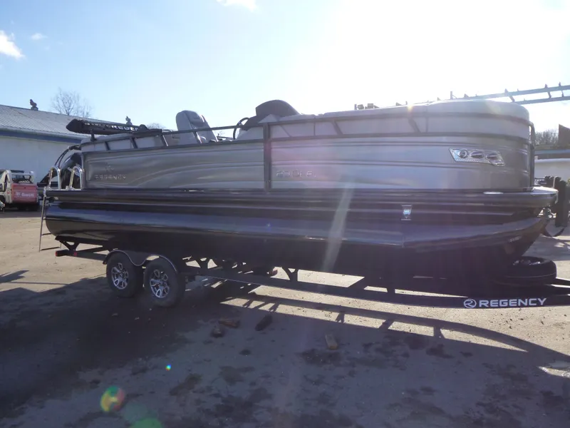 Slide: The Image of 2025 Regency 230 LE3 pontoon boat on trailer in outdoor setting. - 8