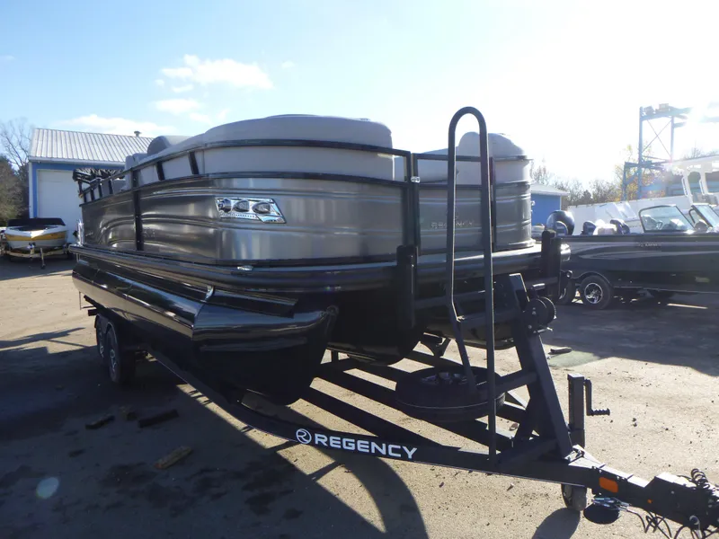 Slide: The Image of 2025 Regency 230 LE3 pontoon boat on trailer in outdoor setting. - 9