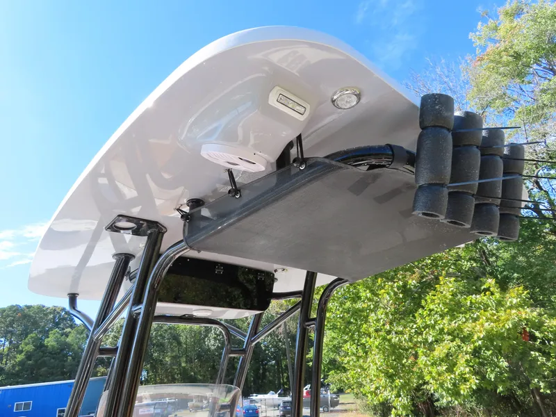 Slide: The Image of 2025 Key West 244 Center Console boat with rod holders and canopy, set against a clear sky. - 13