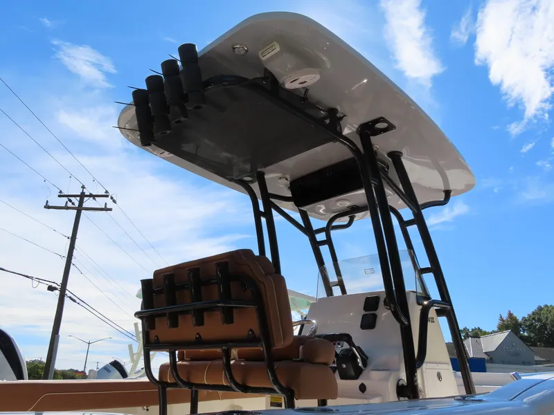 Slide: The Image of 2025 Key West 244 Center Console boat with T-top and rod holders under a blue sky. - 14