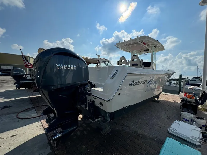 The Image of 2023 Sailfish 290cc boat with Yamaha outboard motor, docked under a sunny sky. - 0