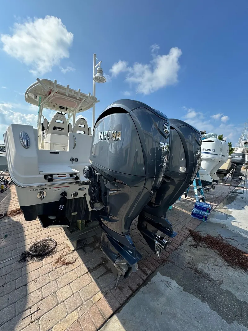 Slide: The Image of 2023 Sailfish 290cc boat with dual Yamaha outboard engines docked under blue sky. - 5