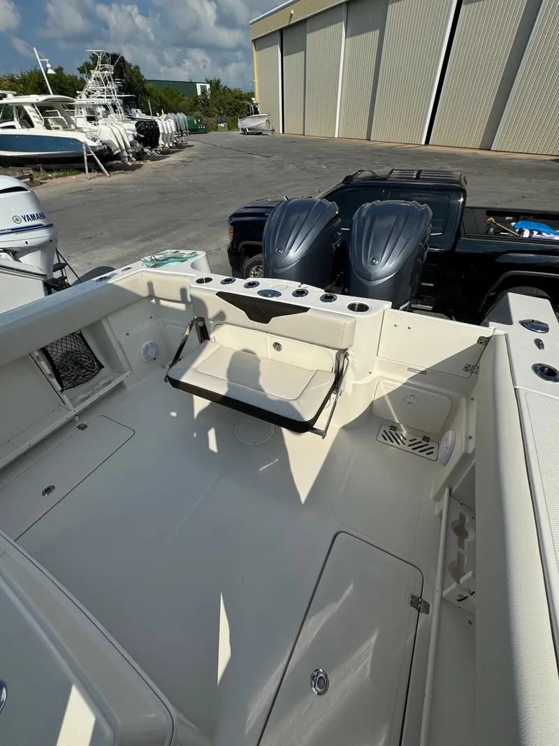 Slide: The Image of 2023 Sailfish 290cc boat interior with dual engines, docked outdoors. - 8