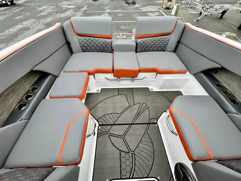 Slide: The Image of 2025 Scarab 255LX boat interior with gray and orange seating, stylish flooring, and cup holders. - 17