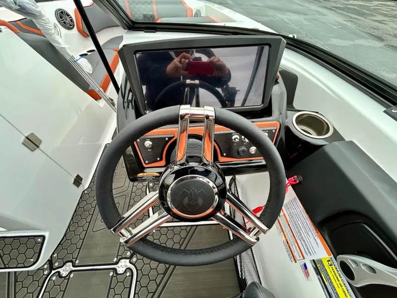 Slide: The Image of 2025 Scarab 255LX boat dashboard with steering wheel and touchscreen display. - 18