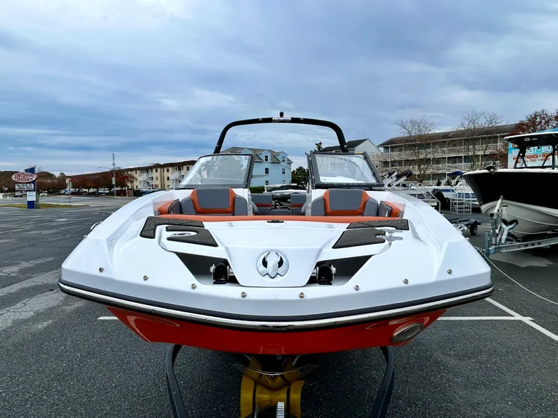 Slide: The Image of 2025 Scarab 255LX boat with sleek design, parked outdoors under cloudy sky. - 2