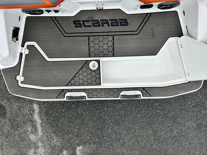 Slide: The Image of 2025 Scarab 255LX boat deck with hexagonal pattern and logo. - 21