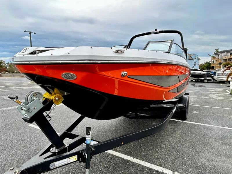 Slide: The Image of 2025 Scarab 255LX boat on trailer in parking lot, featuring sleek red and black design. - 3