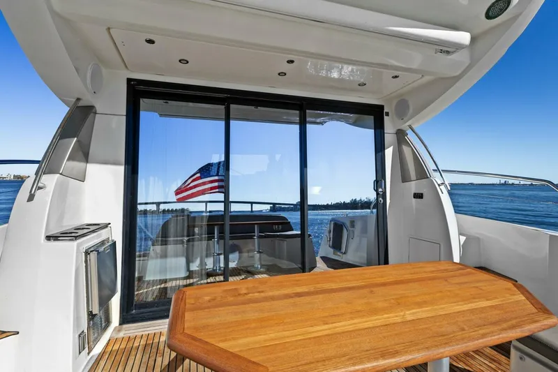 Slide: The Image of Prestige 450 S 2014 yacht deck with wooden table and ocean view. - 10