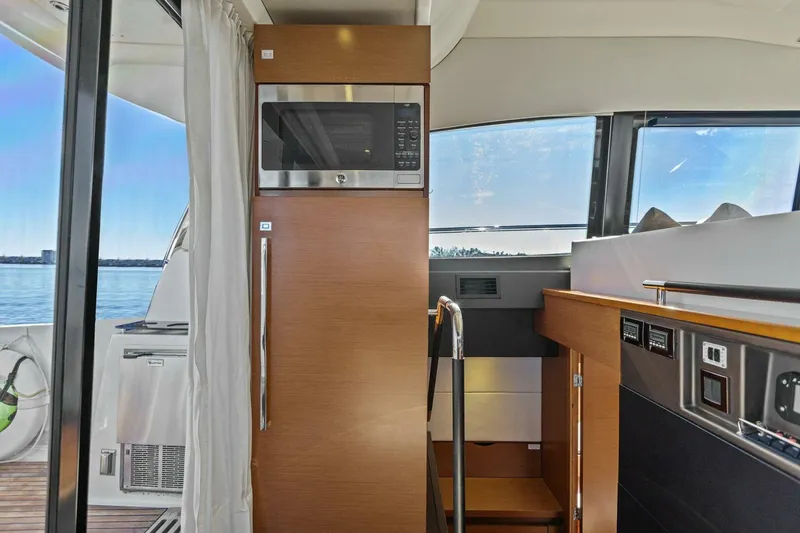 Slide: The Image of Interior of 2014 Prestige 450 S yacht with modern kitchen appliances and scenic window view. - 15