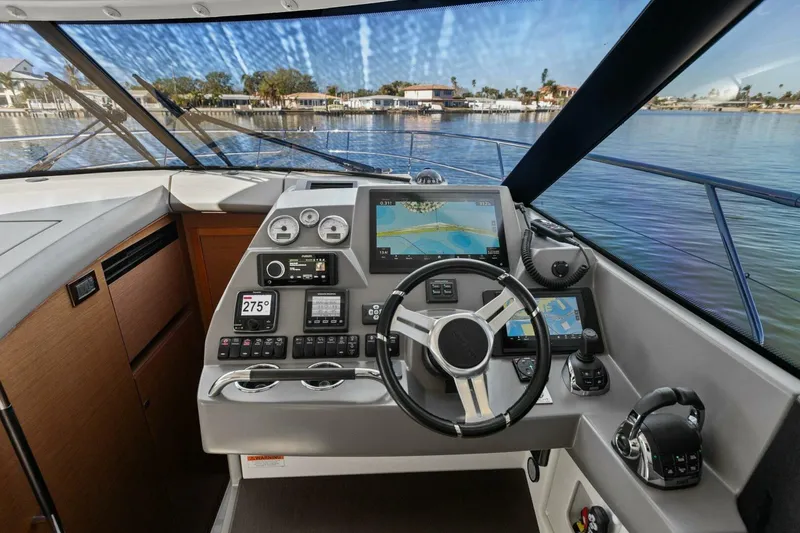 Slide: The Image of Prestige 450 S 2014 yacht cockpit with navigation controls and waterfront view. - 18