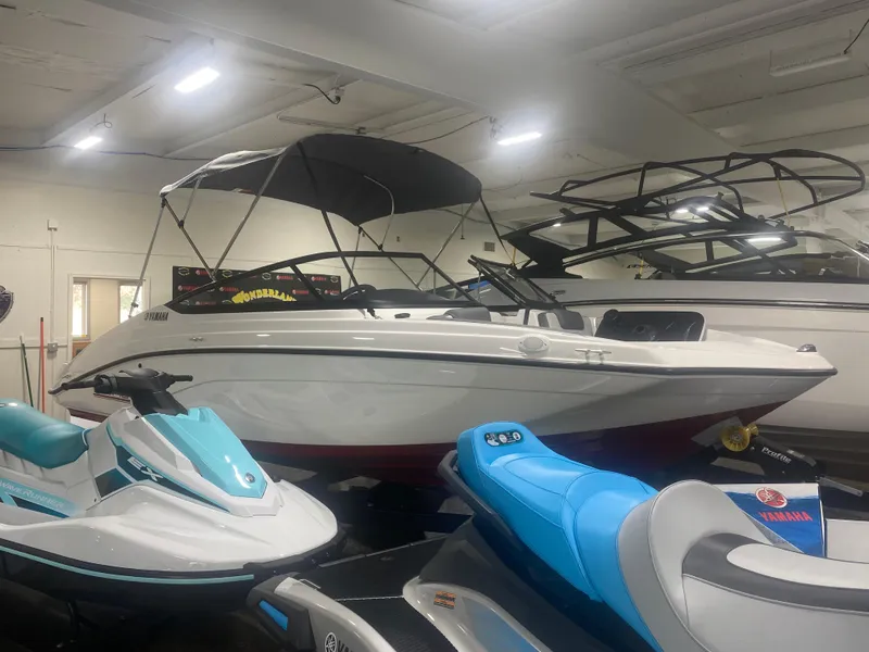 Slide: The Image of 2024 Yamaha SX190 boat displayed indoors with jet skis nearby. - 2