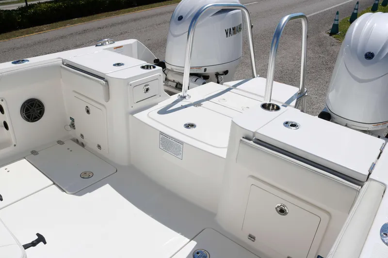 Slide: The Image of 2025 World Cat 235TE boat deck with Yamaha engines, featuring storage compartments and seating. - 15