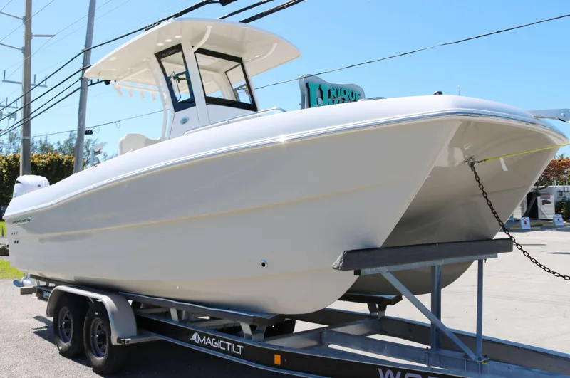 Slide: The Image of 2025 World Cat 235TE boat on trailer, displayed outdoors. - 2