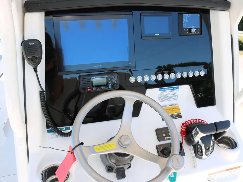 Slide: The Image of Control panel of 2025 World Cat 235TE boat with steering wheel and navigation equipment. - 6