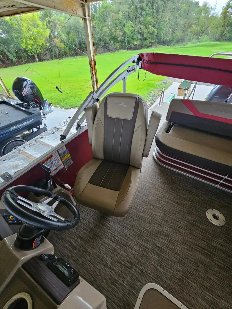 Slide: The Image of 2021 Bennington 22 SX pontoon boat interior with steering wheel and seating. - 18