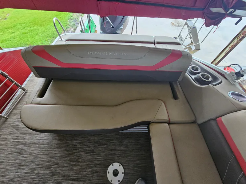 Slide: The Image of 2021 Bennington 22 SX boat interior with red and gray seating and cup holders. - 22