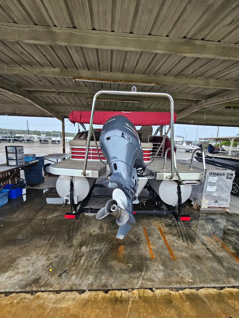 Slide: The Image of 2021 Bennington 22 SX pontoon boat with Yamaha outboard motor under a covered dock. - 27