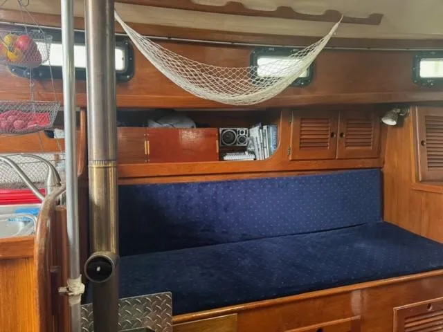 Slide: The Image of Interior of 1984 Sea Sprite 34 Yawl with blue seating and wooden cabinetry. - 2