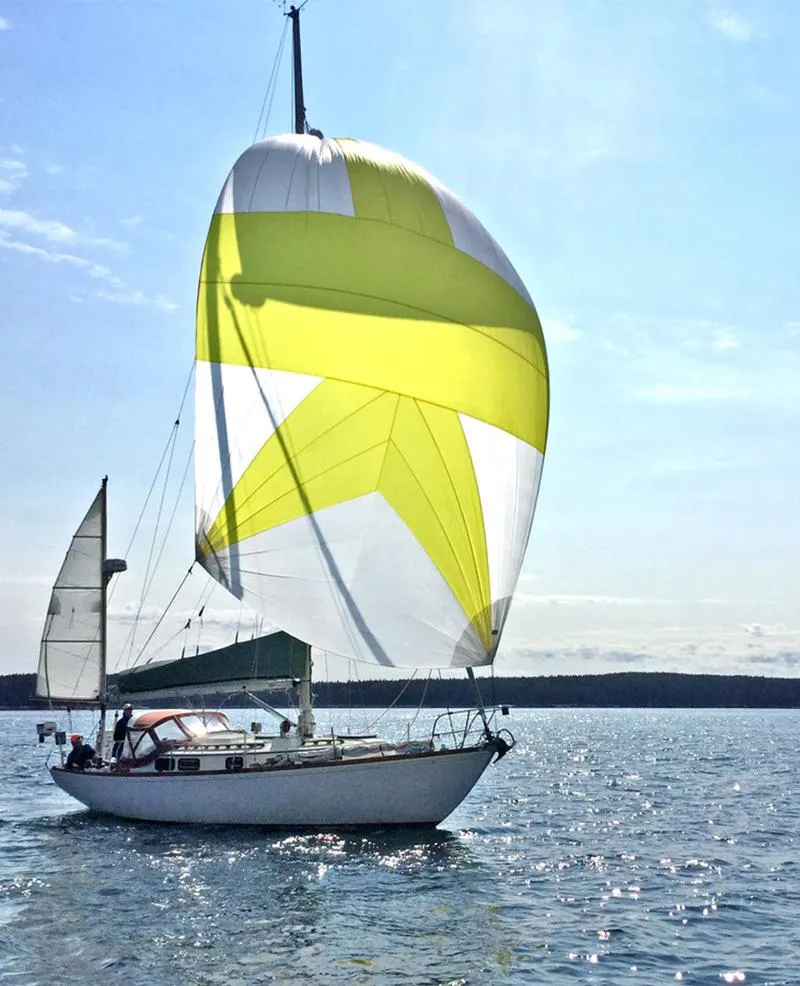Slide: The Image of 1984 Sea Sprite 34 Yawl sailing with vibrant yellow and white spinnaker on open water. - 23