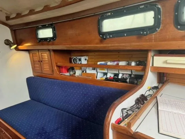 Slide: The Image of Interior of 1984 Sea Sprite 34 Yawl with blue cushioned seating and wooden storage shelves. - 3