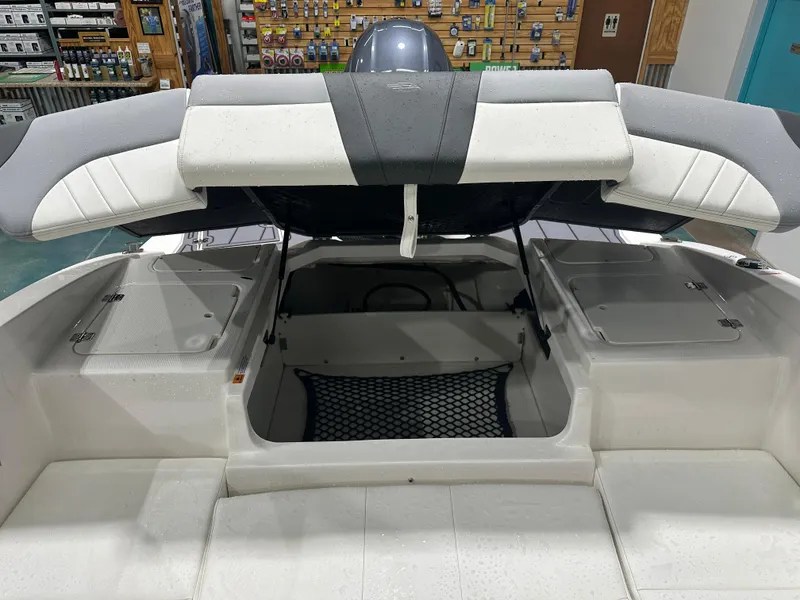 Slide: The Image of 2024 Chaparral SSI21SP boat interior storage compartment with open hatch, showcasing spacious design. - 19