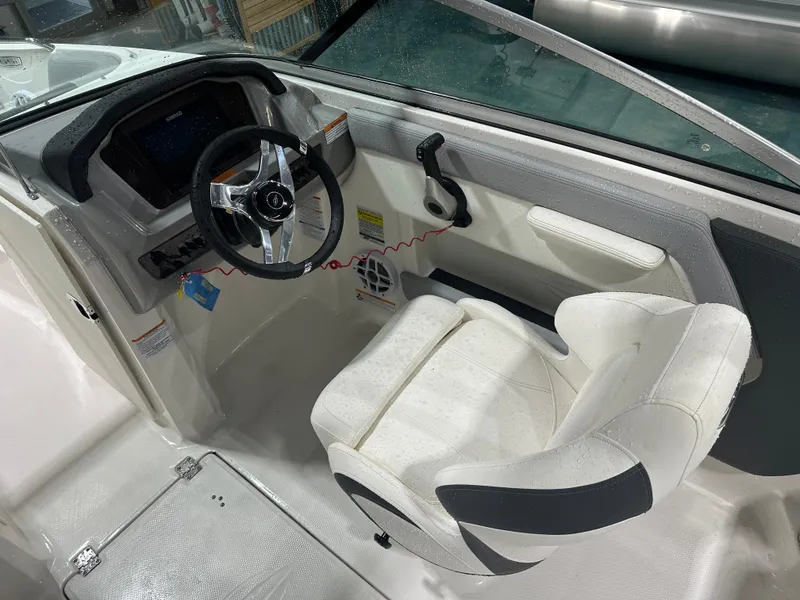 Slide: The Image of 2024 Chaparral SSI21SP boat cockpit with steering wheel and white captain's seat. - 22
