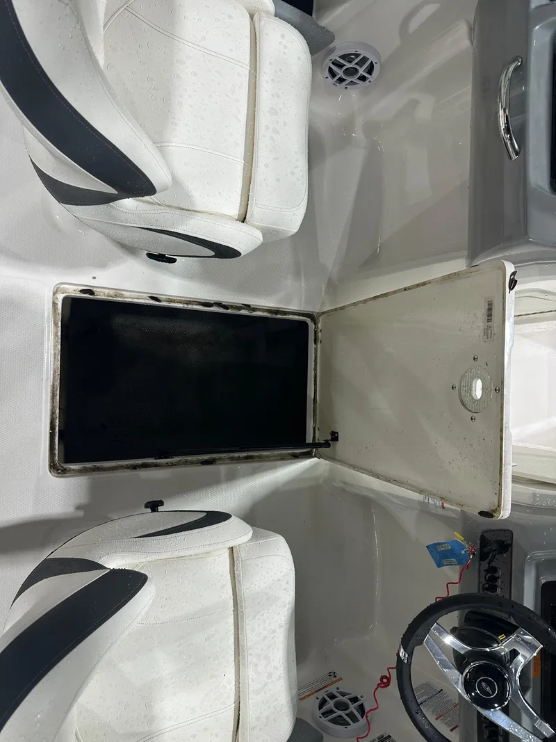 Slide: The Image of 2024 Chaparral SSI21SP boat interior with white seating and storage compartment. - 25