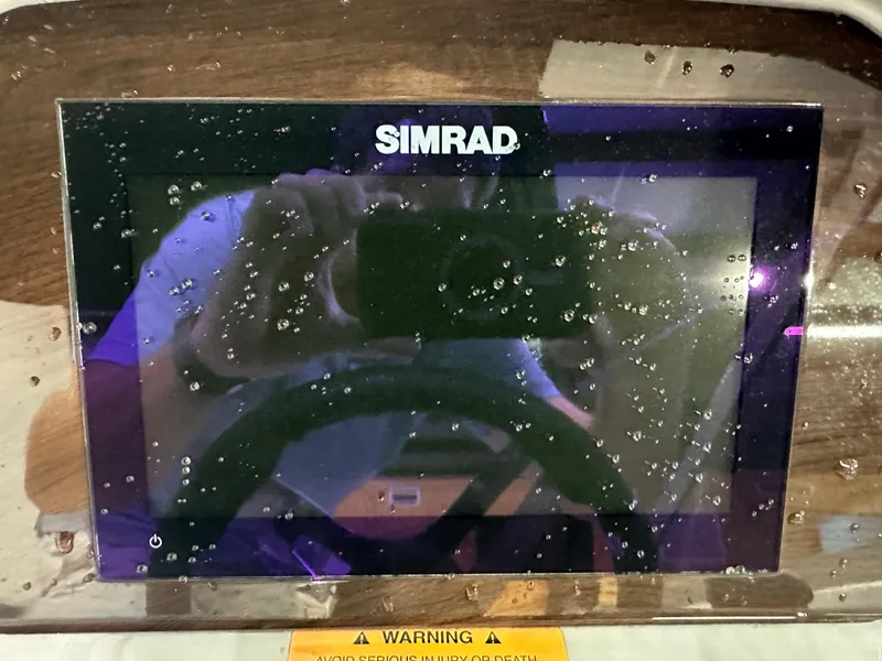 Slide: The Image of Simrad display on 2024 Chaparral SSI21SP boat dashboard with water droplets. - 28