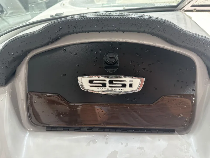 Slide: The Image of 2024 Chaparral SSI21SP dashboard with SSI Outboard emblem, wet surface. - 31