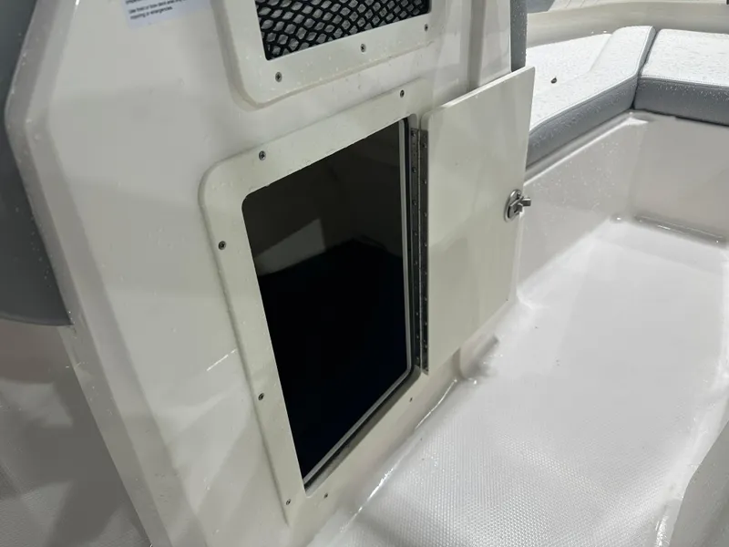Slide: The Image of 2024 Chaparral SSI21SP boat storage compartment with open door, showcasing interior space. - 34
