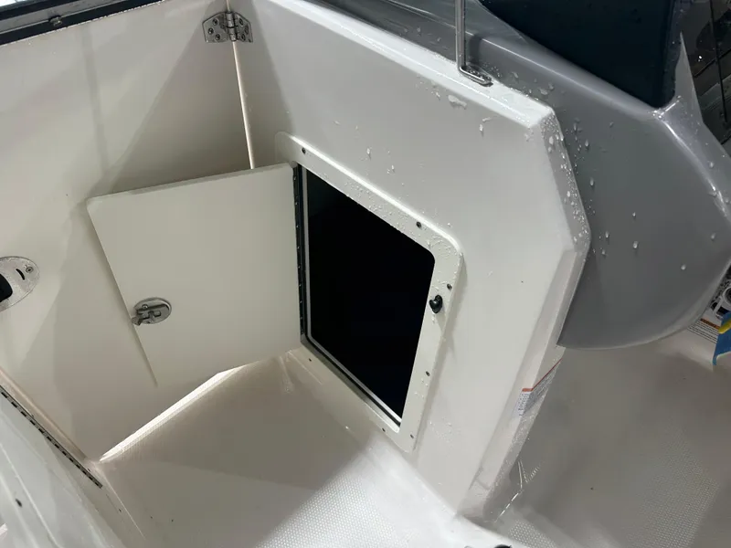 Slide: The Image of 2024 Chaparral SSI21SP boat storage compartment with open hatch, showing interior space. - 36