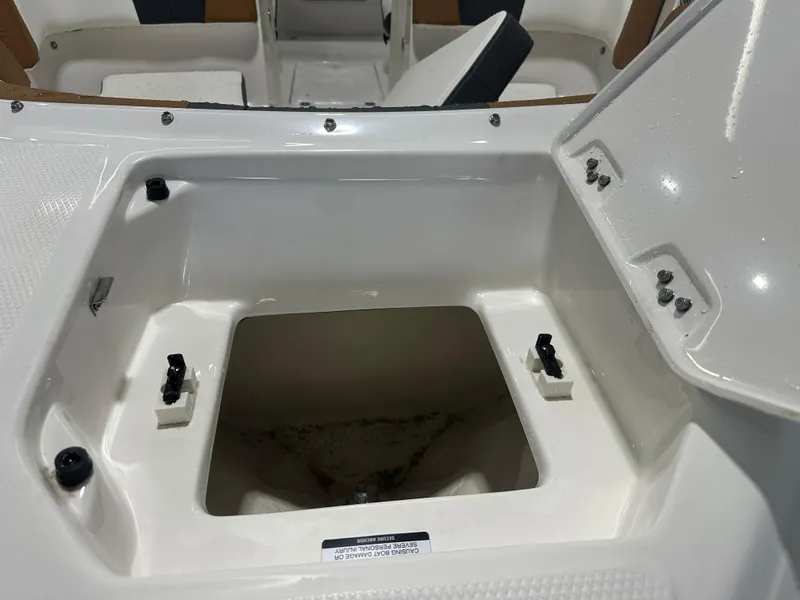 Slide: The Image of 2024 Chaparral SSI23SP boat storage compartment with open lid, showcasing interior details. - 12