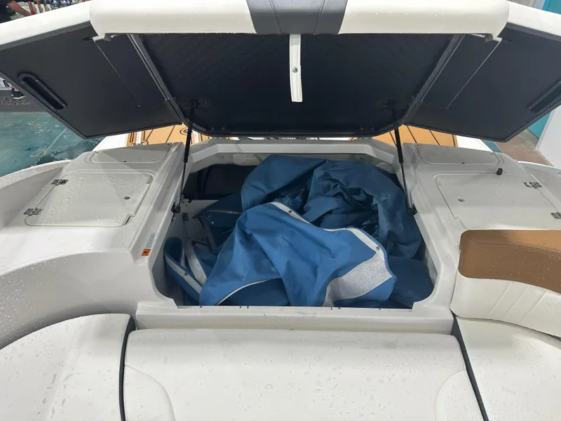 Slide: The Image of 2024 Chaparral SSI23SP boat storage compartment with blue cover inside. - 21