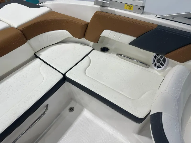 Slide: The Image of 2024 Chaparral SSI23SP boat interior with white and brown seating, featuring a speaker and cup holder. - 22