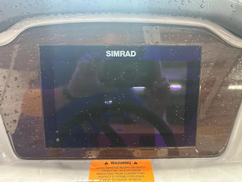 Slide: The Image of Simrad display on 2024 Chaparral SSI23SP boat dashboard with water droplets. - 25