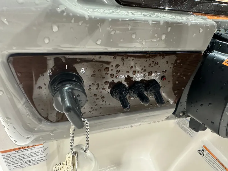 Slide: The Image of 2024 Chaparral SSI23SP boat dashboard with wet control panel and ignition key. - 26