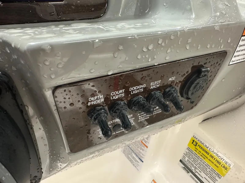 Slide: The Image of Control panel of 2024 Chaparral SSI23SP boat with switches and water droplets. - 27