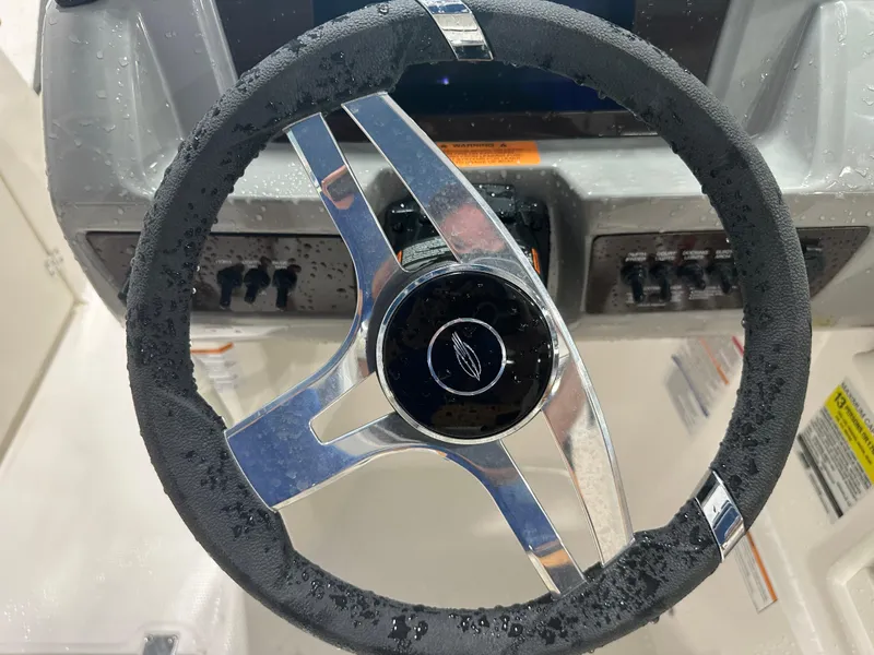 Slide: The Image of 2024 Chaparral SSI23SP steering wheel with water droplets, showcasing sleek design. - 28
