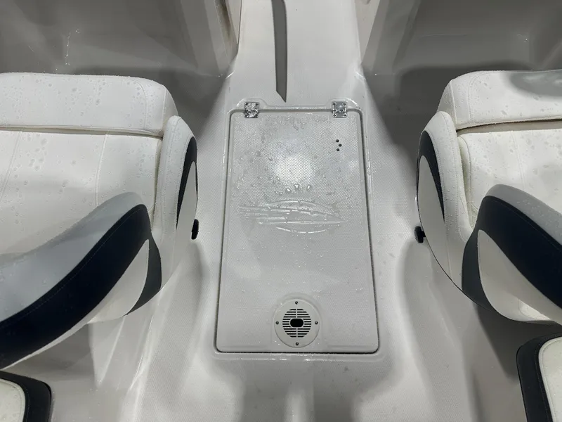 Slide: The Image of 2024 Chaparral SSI23SP boat interior with white seating and central compartment. - 30