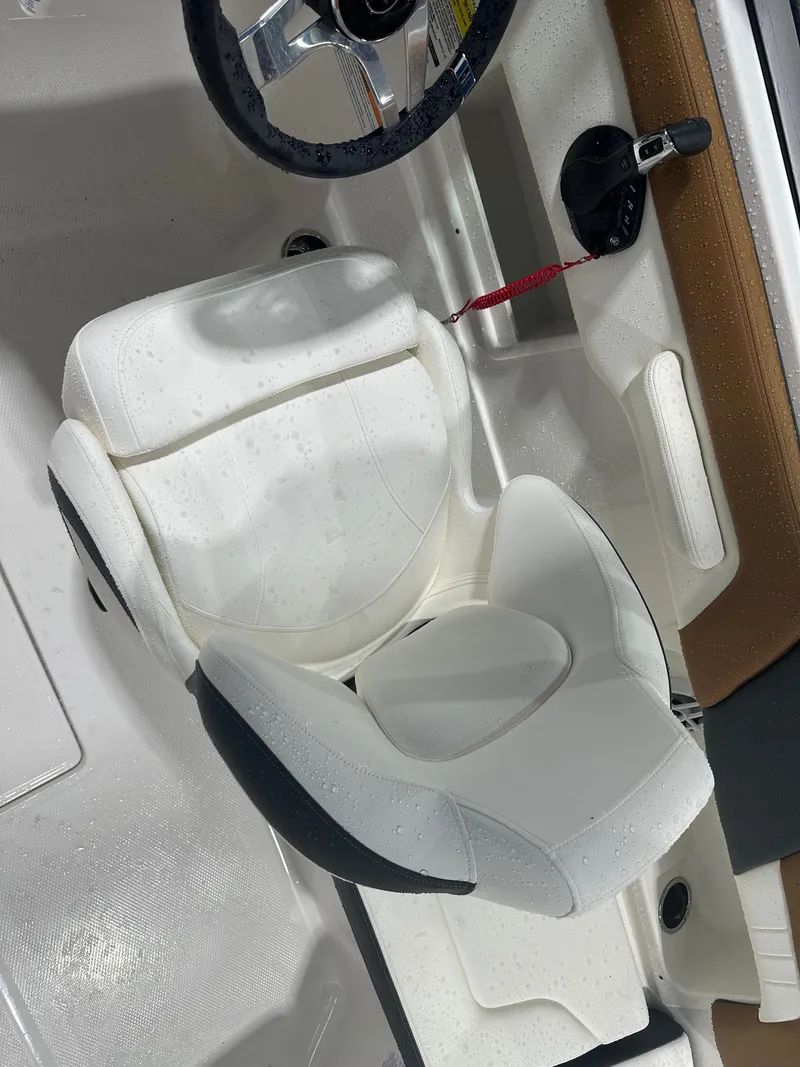 Slide: The Image of 2024 Chaparral SSI23SP boat interior with white captain's seat and steering wheel. - 33