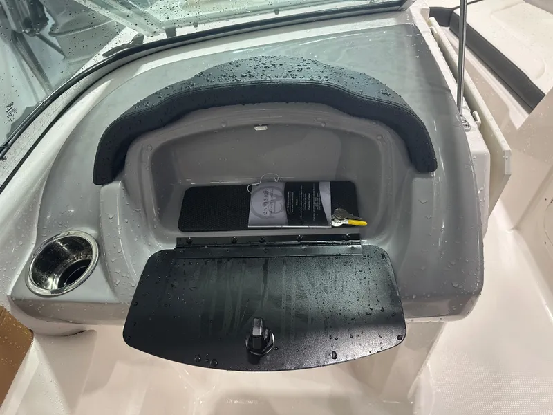 Slide: The Image of 2024 Chaparral SSI23SP boat dashboard with storage compartment and cup holder. - 37