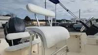 Slide: The Image of Key West 2020CC 2005 boat with white seating and steering wheel, docked outdoors. - 15