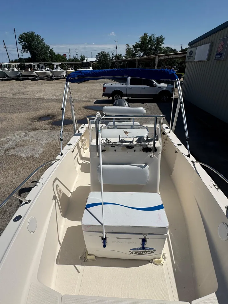 Slide: The Image of 2005 Key West 2020CC boat with blue canopy in a parking lot. - 24